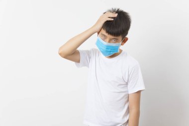  Beyaz arka planda maske takan Asyalı bir çocuk.