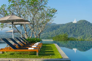 Havuzun yanındaki güvertede tahta bir yatak.