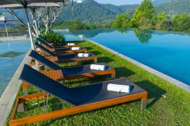 Havuzun yanındaki güvertede tahta bir yatak.