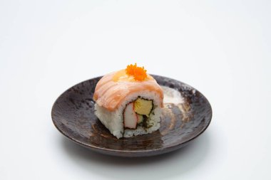 Somonlu suşi rulosu ve beyaz arka planda avokado.