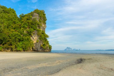 Kayalar ve mavi gökyüzü ile tropik plaj manzarası