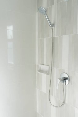 Islak cam pencerenin arkasında taze duş ve su damlaları. Modern banyodaki duş başlığı ve musluktan su akıyor..