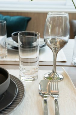 Evdeki ahşap yemek masasında modern siyah tabak.