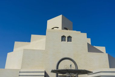 Doha, Katar - 23 Kasım 2019: 23 Kasım 2019 tarihinde Katar 'ın Doha kentinde mavi gökyüzü ile İslam Sanatları Müzesi (MIA). Efsanevi mimar I. M. Pei tarafından tasarlandı..