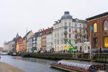 Kopenhag, Danimarka - 26 Kasım 2019: Kopenhag, Danimarka 'da Nyhavn Kanalı boyunca eski gemilerle Nyhavn seti üzerindeki renkli cepheler ve restoranlar.