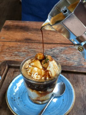 Ahşap masada nefis dondurması olan kahve makinesi.