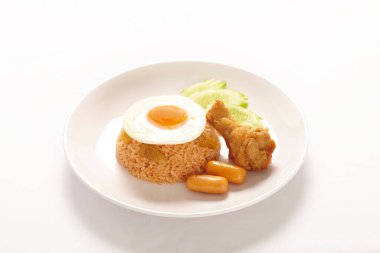 Pirinçli yumurta, sosis ve beyaz tabakta et.