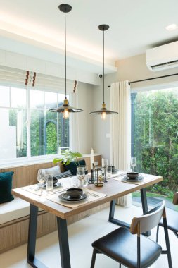 Evdeki ahşap yemek masasında modern siyah tabak.