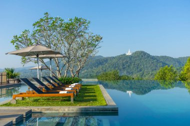 Havuzun yanındaki güvertede tahta bir yatak.