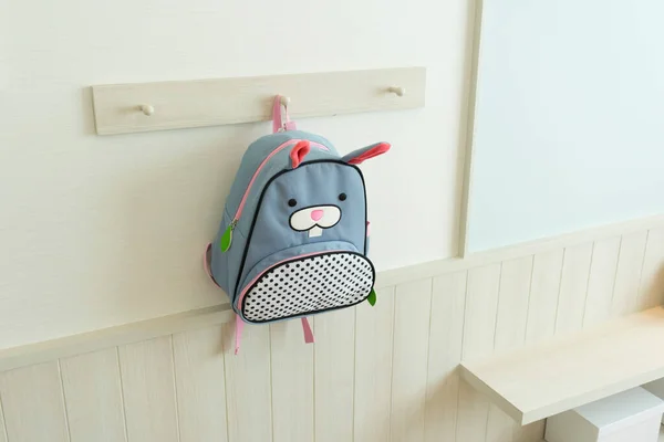 Mavi okul çantası çocuk odasında duvarda asılı..