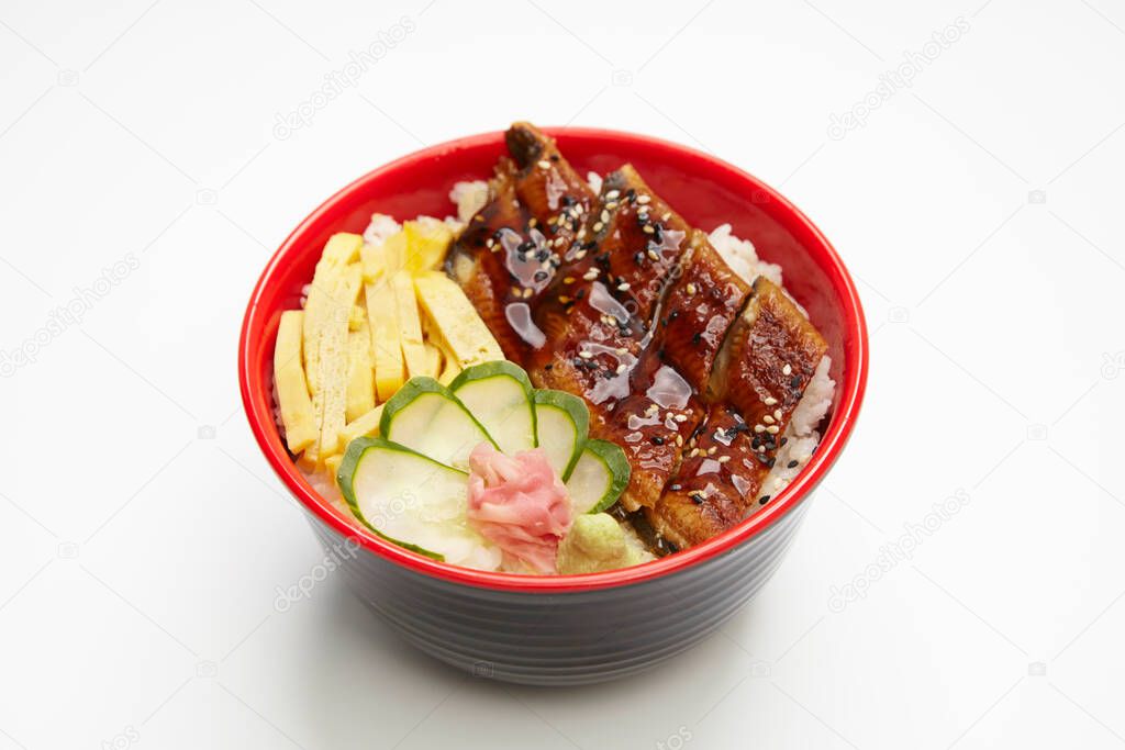 Broiled eel on rice in black bowl on white background. Japanese unagi cuisine