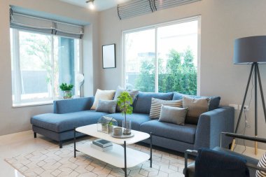 Modern oturma odasının içinde kanepe ve masa var.