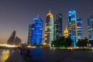 Katar 'ın Doha kentindeki Finansal Bölgedeki modern gökdelenlerin gece silueti.