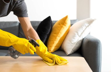 Ev masasını dezenfektan spreyle temizleme havluyla ve eldivenle. COVID-19 önleme.