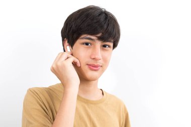 neşeli yakışıklı çocuk 10-12y kulaklık takıyor beyaz arka planda gülümsüyor.
