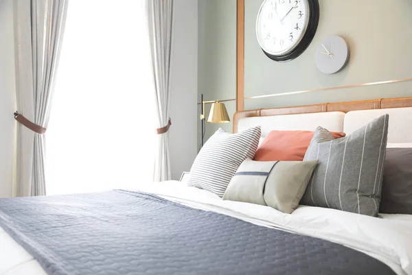 stock image Stylish interior of a modern bedroom with clocks on the wall.