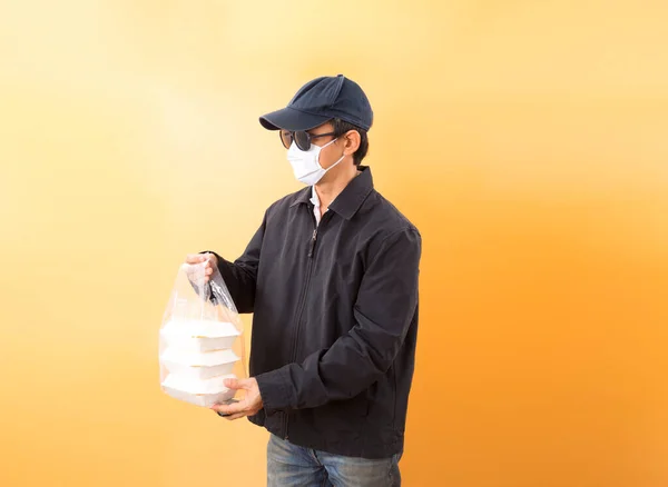 Asian Delivery Man Protective Mask Holding Food Box Pastel Background — Stock Photo, Image