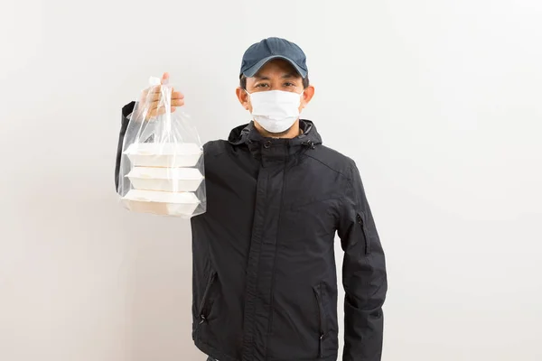 Ασιάτης Ντελιβεράς Προστατευτική Μάσκα Που Κρατάει Κουτί Φαγητού Πάνω Από — Φωτογραφία Αρχείου