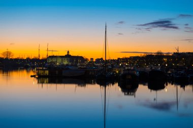Amsterdam, Hollanda - 30 Kasım 2019: 30 Kasım 2019 'da Hollanda' nın Amsterdam kentindeki Merkez Tren İstasyonu 'nun etrafındaki körfezin güzel gündoğumu manzarası.