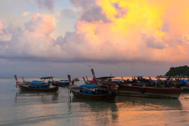Sunset above small harbor with long tail boats at Ko Lipe island, Thailand. 