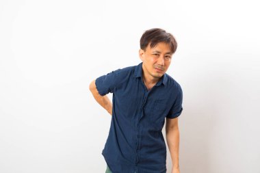 Orta yaşlı Asyalı adam sırt ağrısı çekiyor.