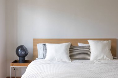 Yatak odasının iç kısmında lamba bulunan beyaz yastıklara yakın çekim..