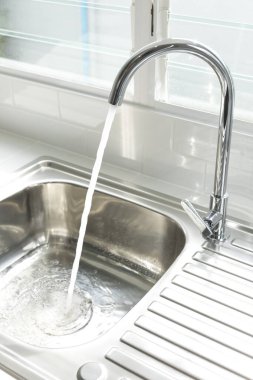 Metal lavabo ve musluk, akan suyla..
