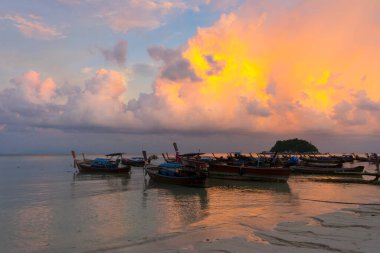 Sunset above small harbor with long tail boats at Ko Lipe island, Thailand. 