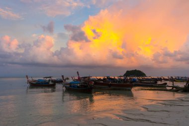 Sunset above small harbor with long tail boats at Ko Lipe island, Thailand. 