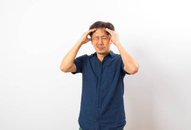 Orta yaşlı Asyalı adam baş ağrısı çekiyor.