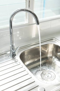 Metal lavabo ve musluk, akan suyla..