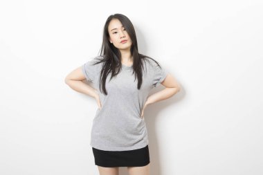 Asyalı güzel bir kadının portresi gülümsüyor ve beyaz arka planda duruyor..