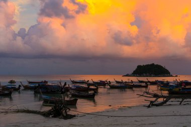 Sunset above small harbor with long tail boats at Ko Lipe island, Thailand. 
