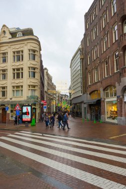 Amsterdam, Hollanda - 27 Kasım 2019: Amsterdam, Hollanda 'da Damrak merkez caddesinde yürüyen kimliği belirsiz kişiler