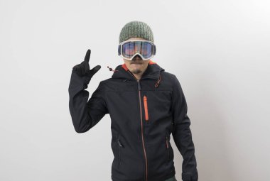 Kışlık ceketli, gözlüklü ve eldivenli beyaz arka planda snowboardcu için giyinmiş Asyalı bir adam..