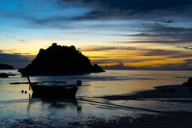 Koh Lipe Adası, Satun, Tayland 'da gün batımında tropikal sahilde tekne siluetleri.
