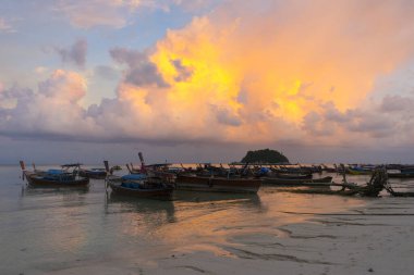 Sunset above small harbor with long tail boats at Ko Lipe island, Thailand. 
