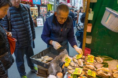 Tokyo, Japonya - 4 Ocak 2020: Tokyo, Japonya 'daki Tsukiji Balık Pazarı' nda 4 Ocak 2020 tarihinde deniz ürünleri satan tüccar. Dünyadaki en büyük toptan balık ve deniz ürünleri pazarıdır..