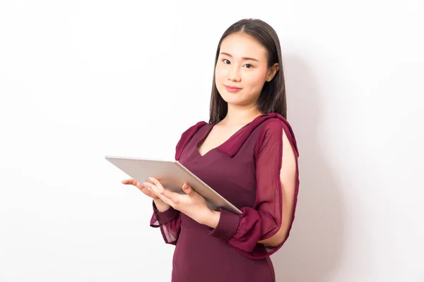 Young asian woman, company worker smiling and holding digital tablet, standing over white background