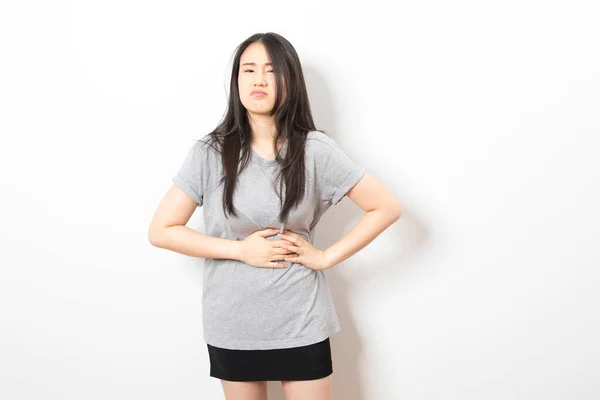 漂亮的亚洲女人穿着宽松的灰色T恤 因为消化不良而手拉手 肚子痛 — 图库照片