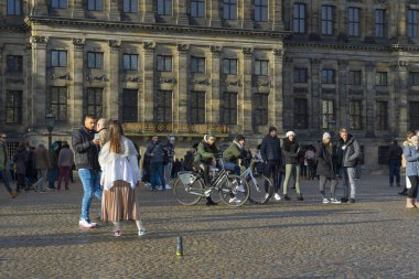 Amsterdam, Hollanda - 29 Kasım 2019: 29 Kasım 2019 'da Amsterdam, Hollanda' daki Royal Palace Amsterdam ve Baraj Meydanı 'nın önünde kimliği belirsiz birçok kişi havanın tadını çıkarıyor.