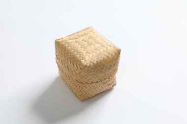 Beyaz arka planda yapışkan pirinç için bir bambu sepeti..