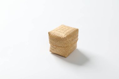 Beyaz arka planda yapışkan pirinç için bir bambu sepeti..