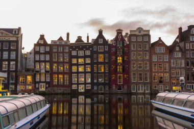 Amsterdam, Hollanda - 27 Kasım 2019: Amsterdam, Hollanda 'da 27 Kasım 2019' da sabah ışığında Amsterdam Kanalı 'ndaki ev ve teknelerin görüntüsü.