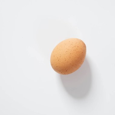 Beyaz arka planda bir kahverengi yumurta.