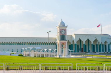 Doha, Katar - 22 Kasım 2019: Katar 'ın Doha kentindeki Corniche gezinti alanından Amiri Diwan hükümet kompleksi ve Musevir Camii' nin manzarası