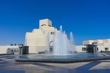 Doha, Katar - 23 Kasım 2019: 23 Kasım 2019 tarihinde Katar 'ın Doha kentinde mavi gökyüzü ile İslam Sanatları Müzesi (MIA). Efsanevi mimar I. M. Pei tarafından tasarlandı..