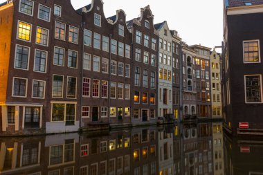 Amsterdam, Hollanda - 27 Kasım 2019: Amsterdam, Hollanda 'da 27 Kasım 2019' da sabah ışığında Amsterdam Kanalı 'ndaki ev ve teknelerin görüntüsü.