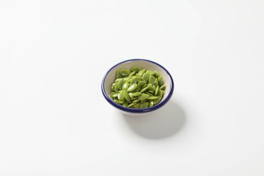 Beyaz arka plandaki bir kasede Acacia tohumlarını soy. Tayland yemeği pişirmek için..