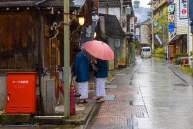 Nagano, Japonya - 16 Aralık 2019: Japonya 'nın Nagano şehrindeki Shibu Onsen şehrindeki tarihi ryokan caddesinde yürüyen kimliği belirsiz bir çift ve sıcak bahar otelleri, 16 Aralık 2019.